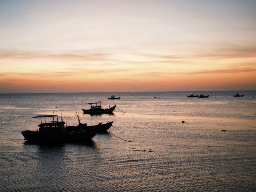 Idyllic image of fishing boats at sunset in Bình Thuận, Vietnam, capturing a serene coastal scene.