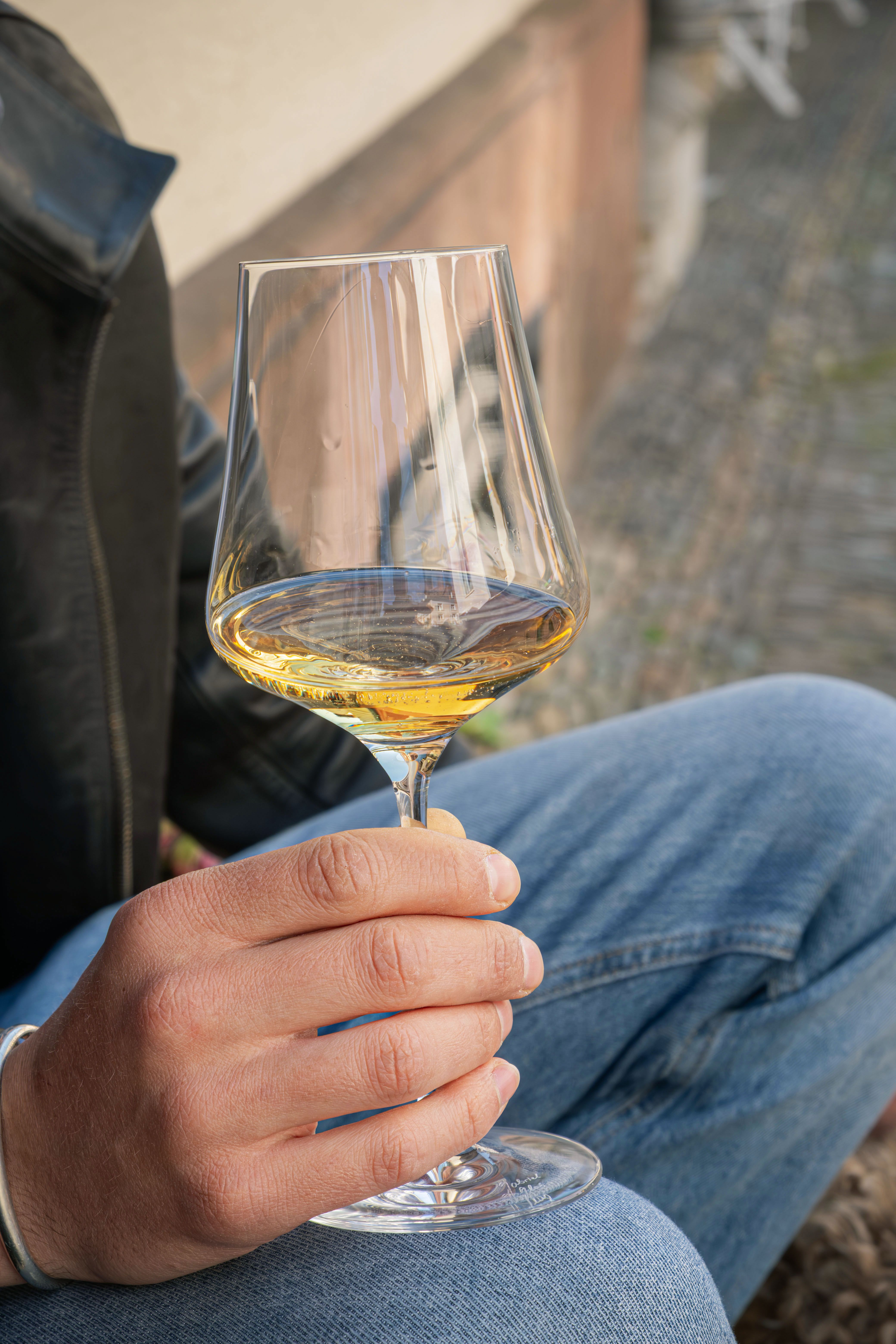 Adult enjoying a glass of white wine outdoors in Freiburg, Germany.