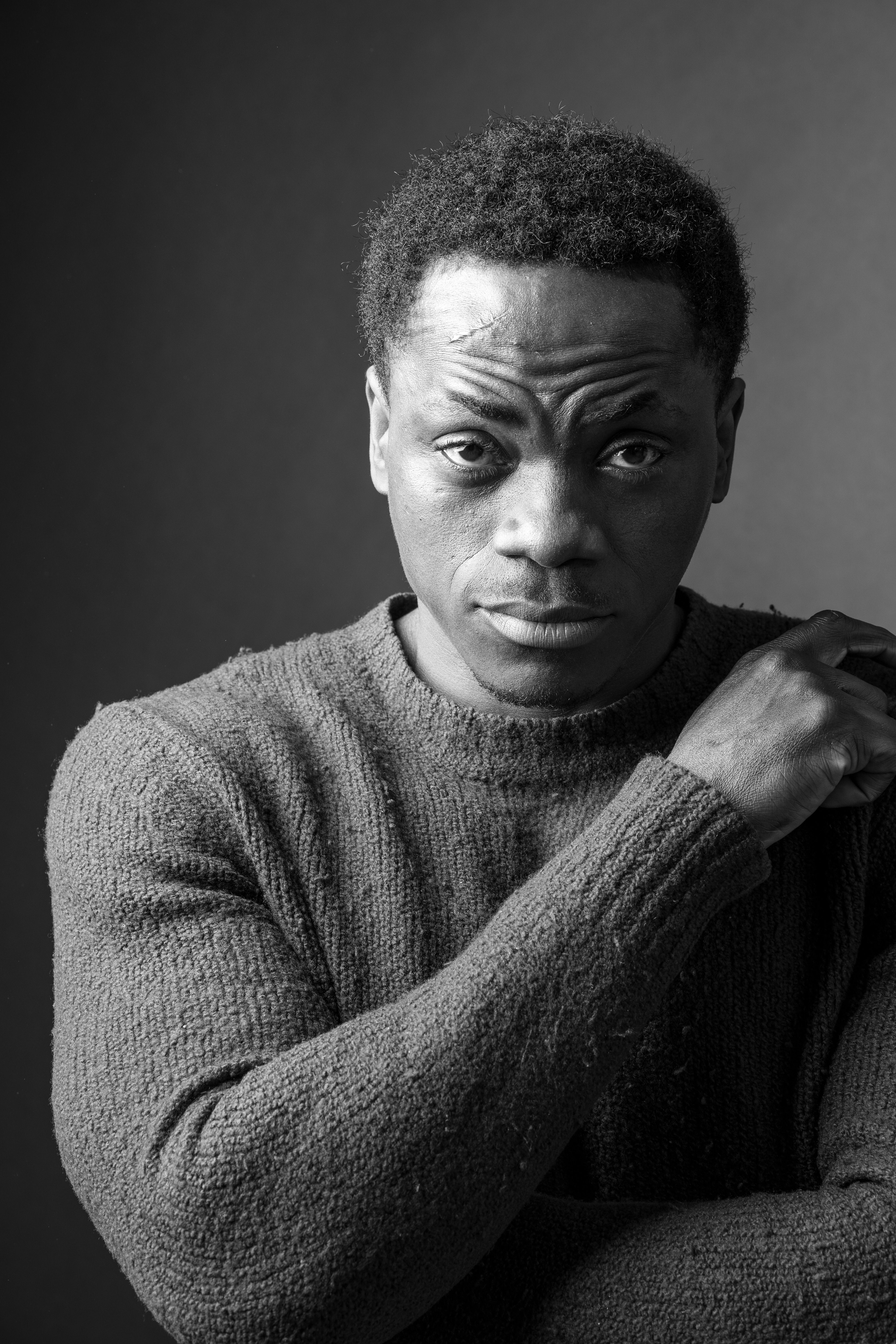 Emotive black and white portrait of a man in a textured sweater, conveying depth.