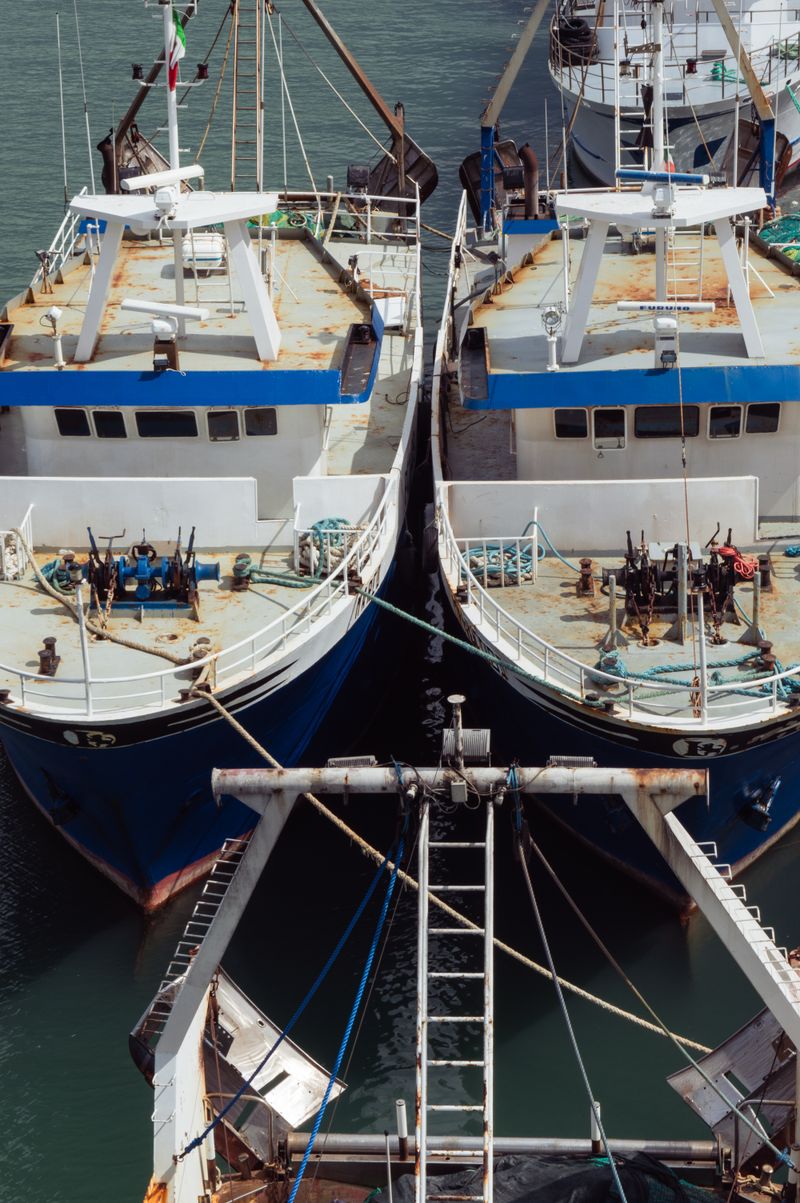 Overhead shot of two fishing boats moored side-by-side at the harbor