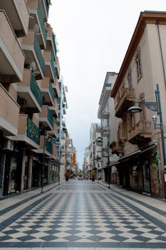 A serene pedestrian street lined with unique architectural buildings and ornate balconies.