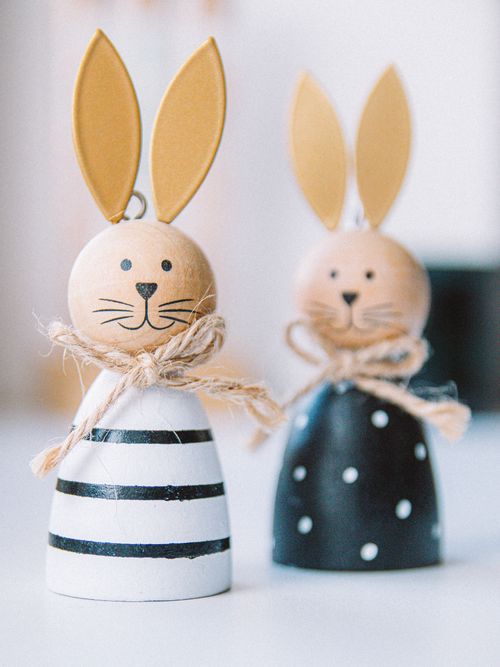 Free Cute wooden Easter bunny figurines with colorful outfits and playful designs. Stock Photo
