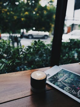 泰国咖啡馆里，一个设计成心形的舒适咖啡杯与杂志窗相映成趣