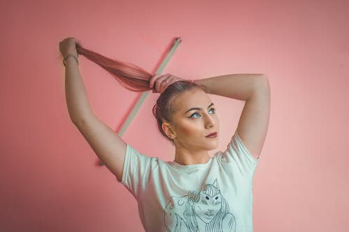 Free Woman Bunching  Her Long Hair While Looking Up Stock Photo