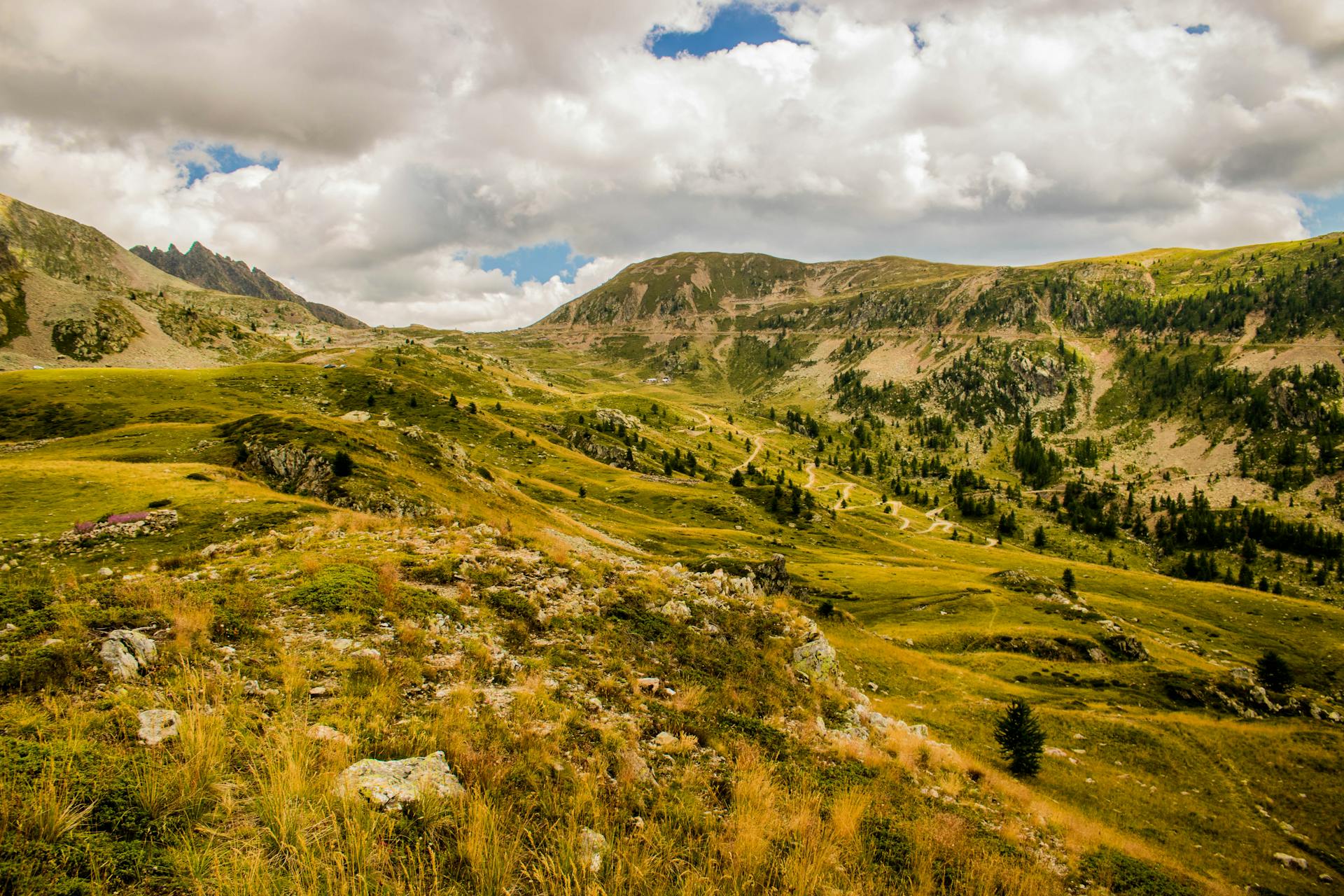 Serene landscape of Italian mountains and valleys under a cloudy sky.