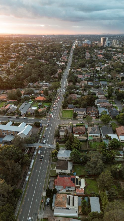 Free Aerial panorama of a suburban Sydney neighborhood during sunset, showcasing residential streets and greenery. Stock Photo