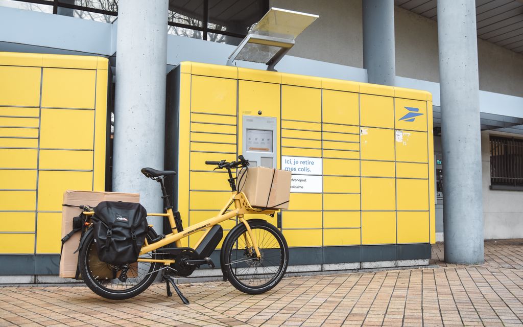 Csomagokkal megrakott elektromos teherkerékpár egy városi átvételi ponton, a gyors last-mile kézbesítést jelképezve.