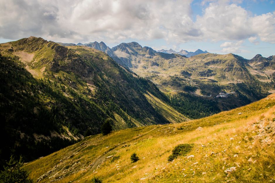 A breathtaking view of the Italian mountain range with grassy fields and clear blue sky.