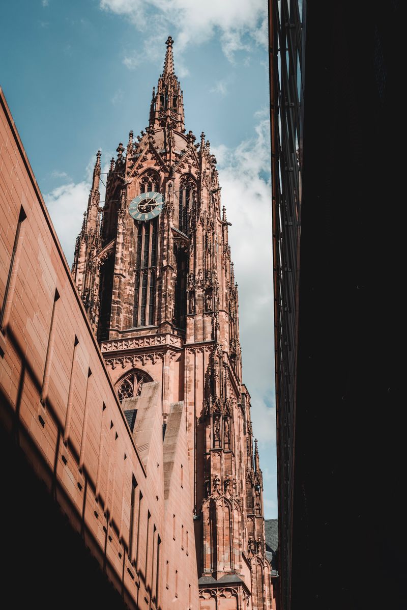 Iconic Gothic tower of Frankfurt Cathedral against a blue sky