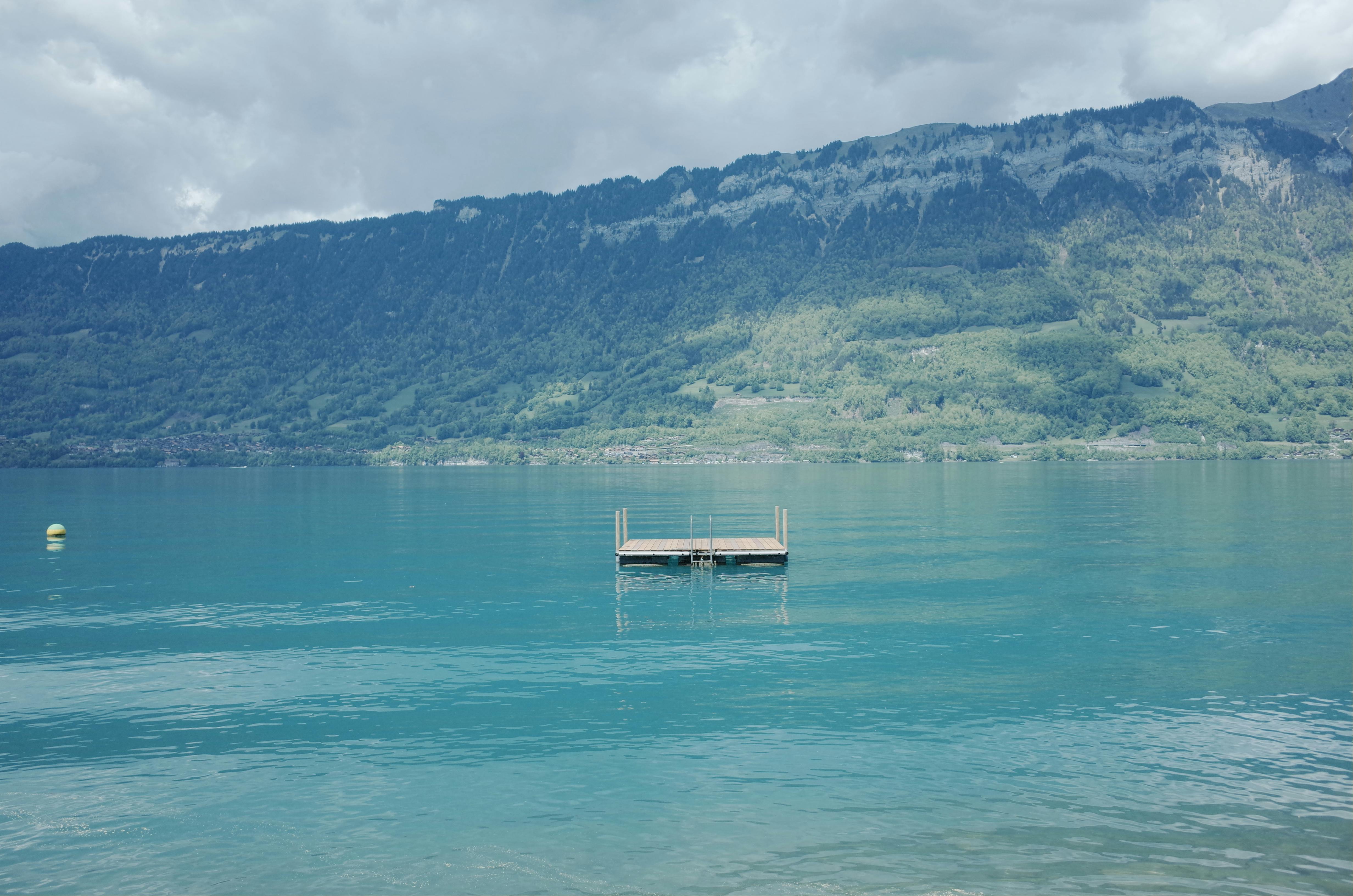Peaceful view of a floating dock on Lake Brienz against lush Swiss mountains.