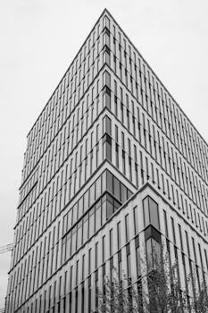 Dramatic angle of a black and white modern office building showcasing architectural symmetry.