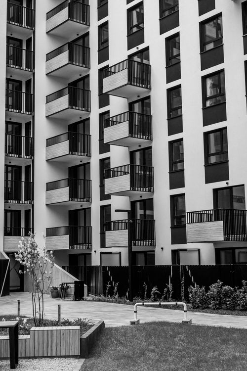 Free Black and white photo of a modern apartment building with balconies, sleek design. Stock Photo