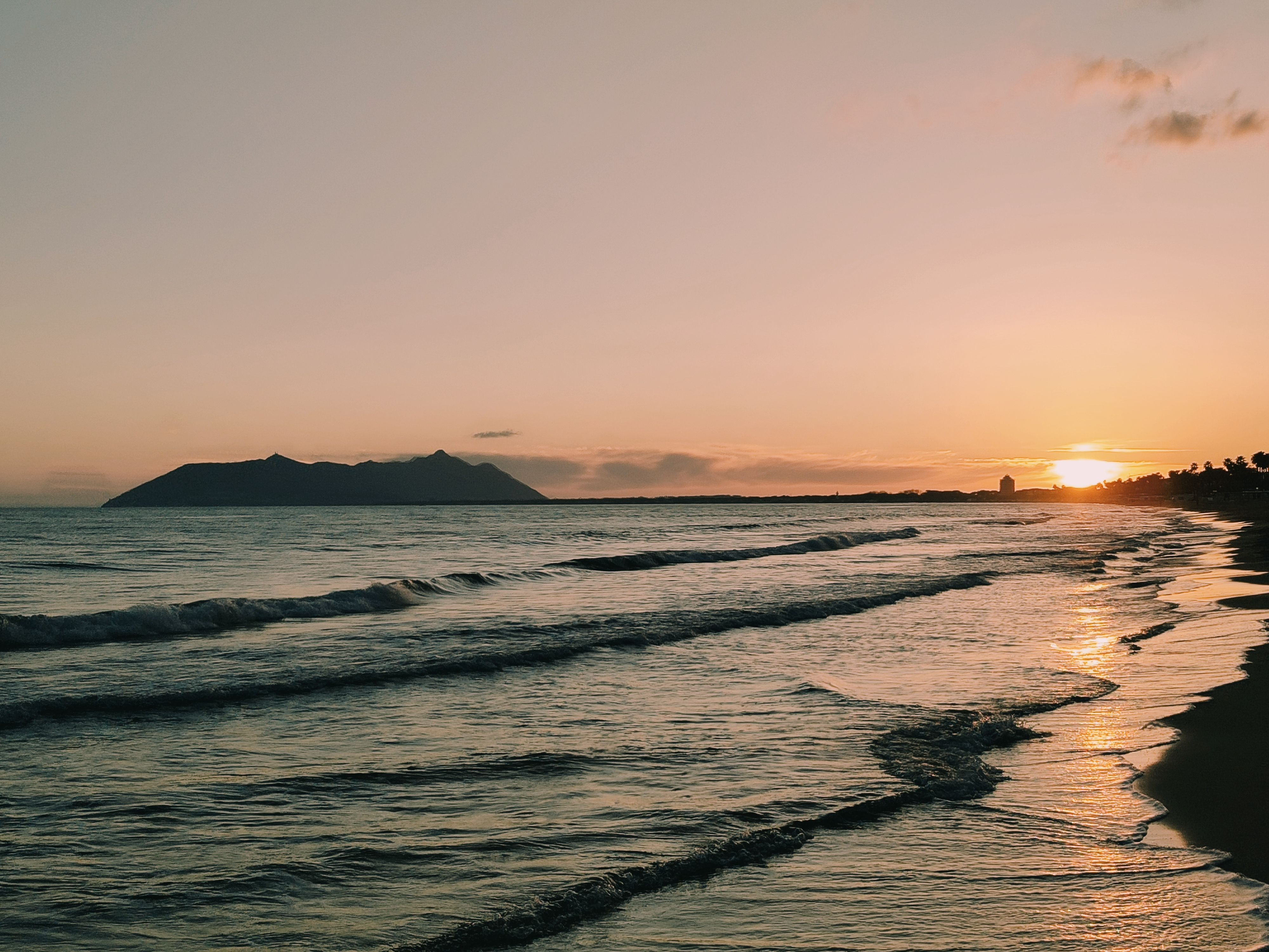 Serene Beach Sunset with Gentle Waves · Free Stock Photo