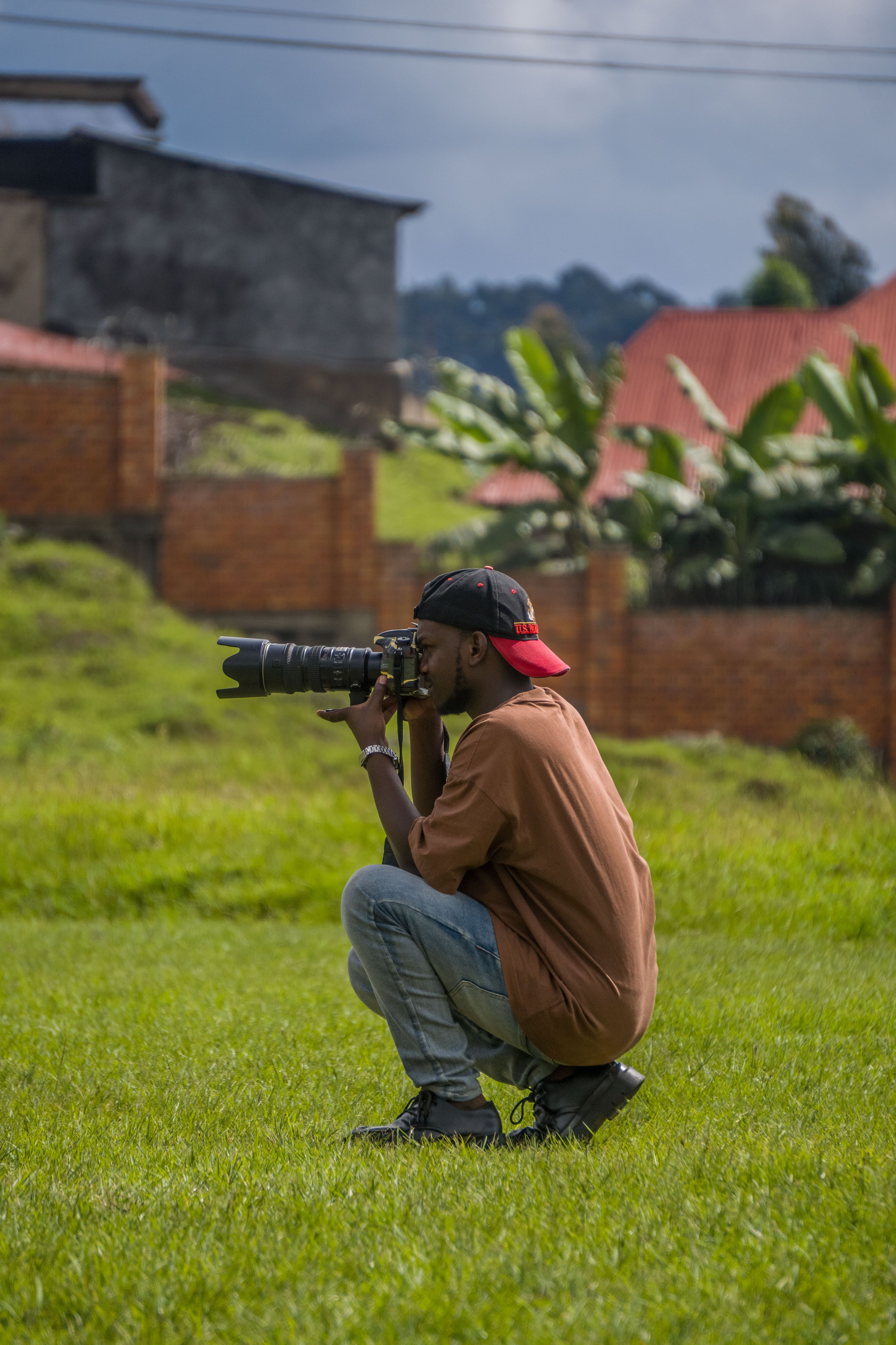 Man photographing outdoors with a large telephoto lens, capturing natural beauty.