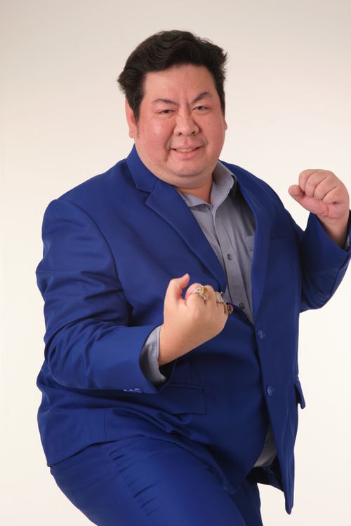 Free Adult man in a blue suit striking a dynamic pose with fists raised, exuding confidence and vitality. Stock Photo