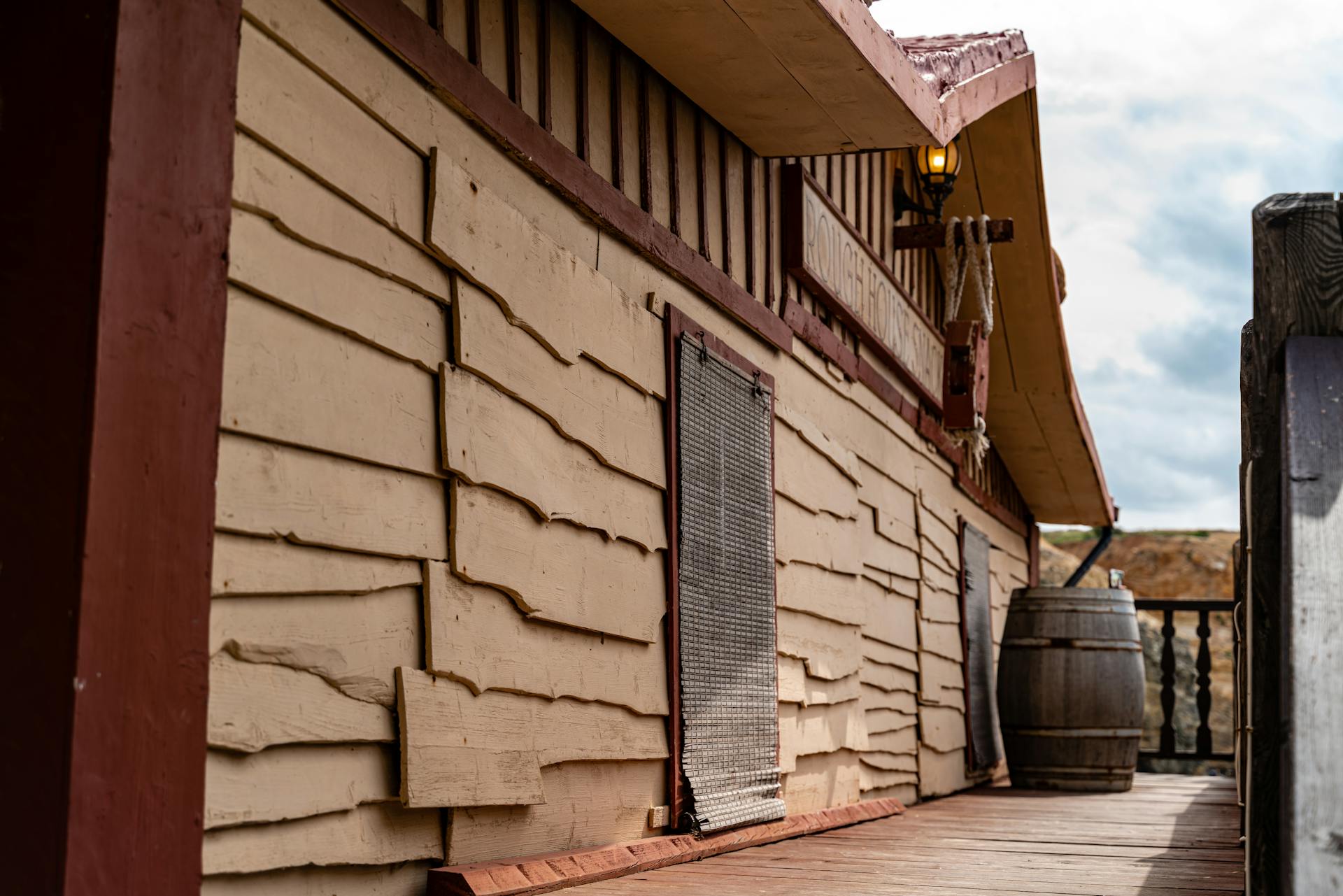 Wooden structure with textured siding and barrel, Malta. Warm tones and rustic charm.
