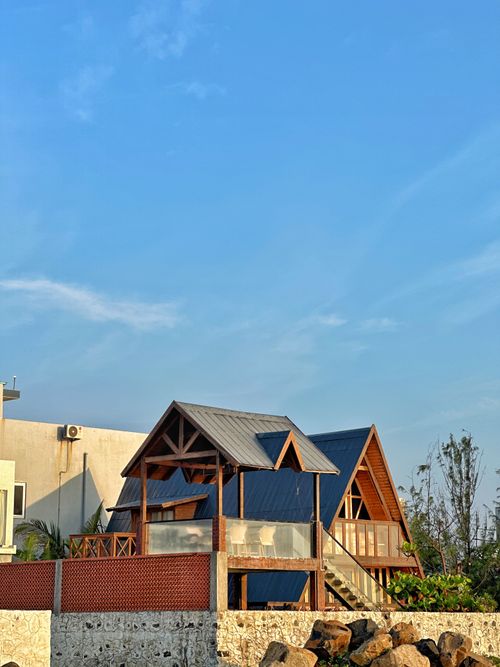 Free Charming A-frame house with rustic design under a clear blue sky, perfect for vacation getaways. Stock Photo