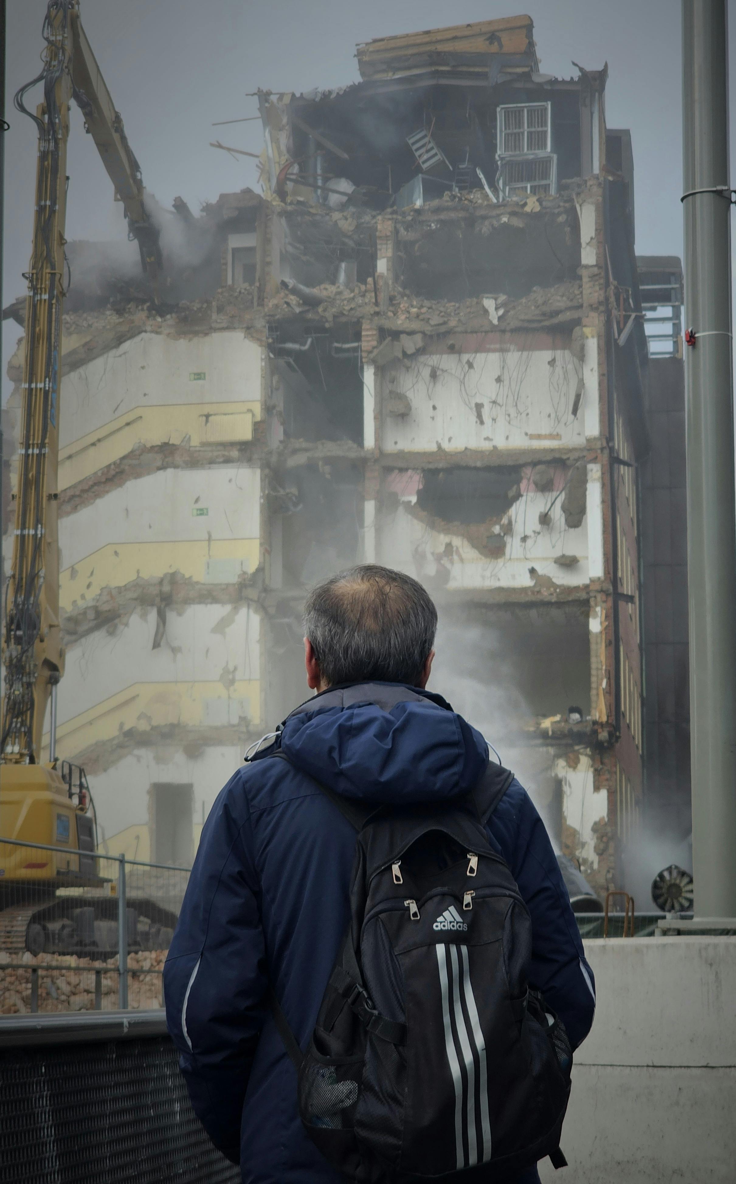 man observing building demolition scene