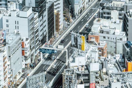 Dynamic aerial view of a bustling cityscape with highways and tall buildings.