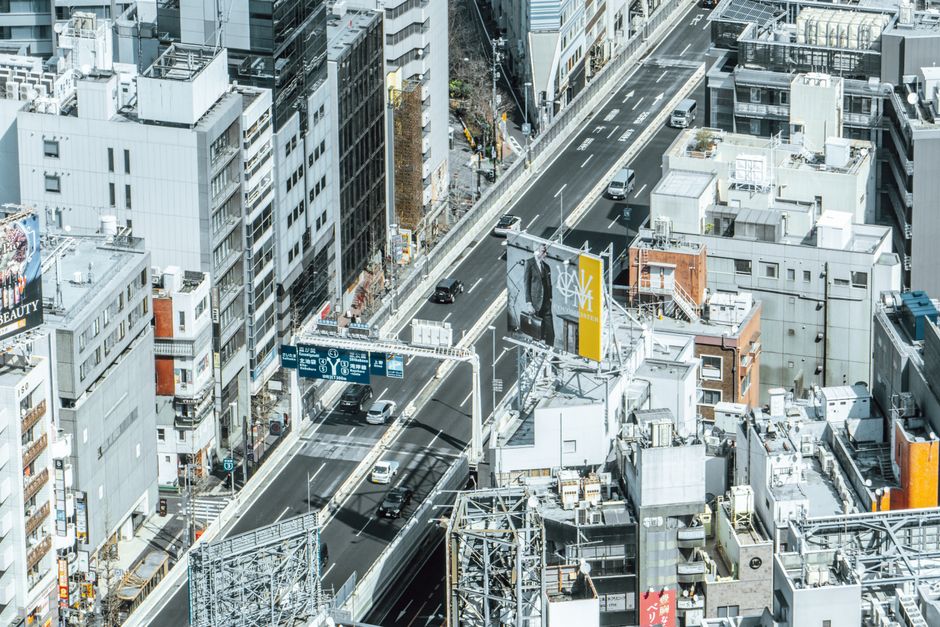 高速道路と高層ビルが立ち並ぶ賑やかな都市景観を空撮したダイナミックな写真です。
