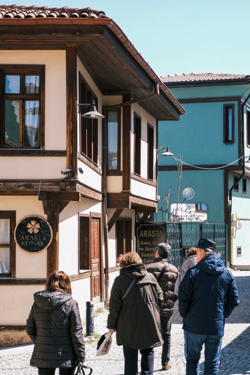 Free A group of people walking past traditional Ottoman-style buildings on a sunny day. Stock Photo