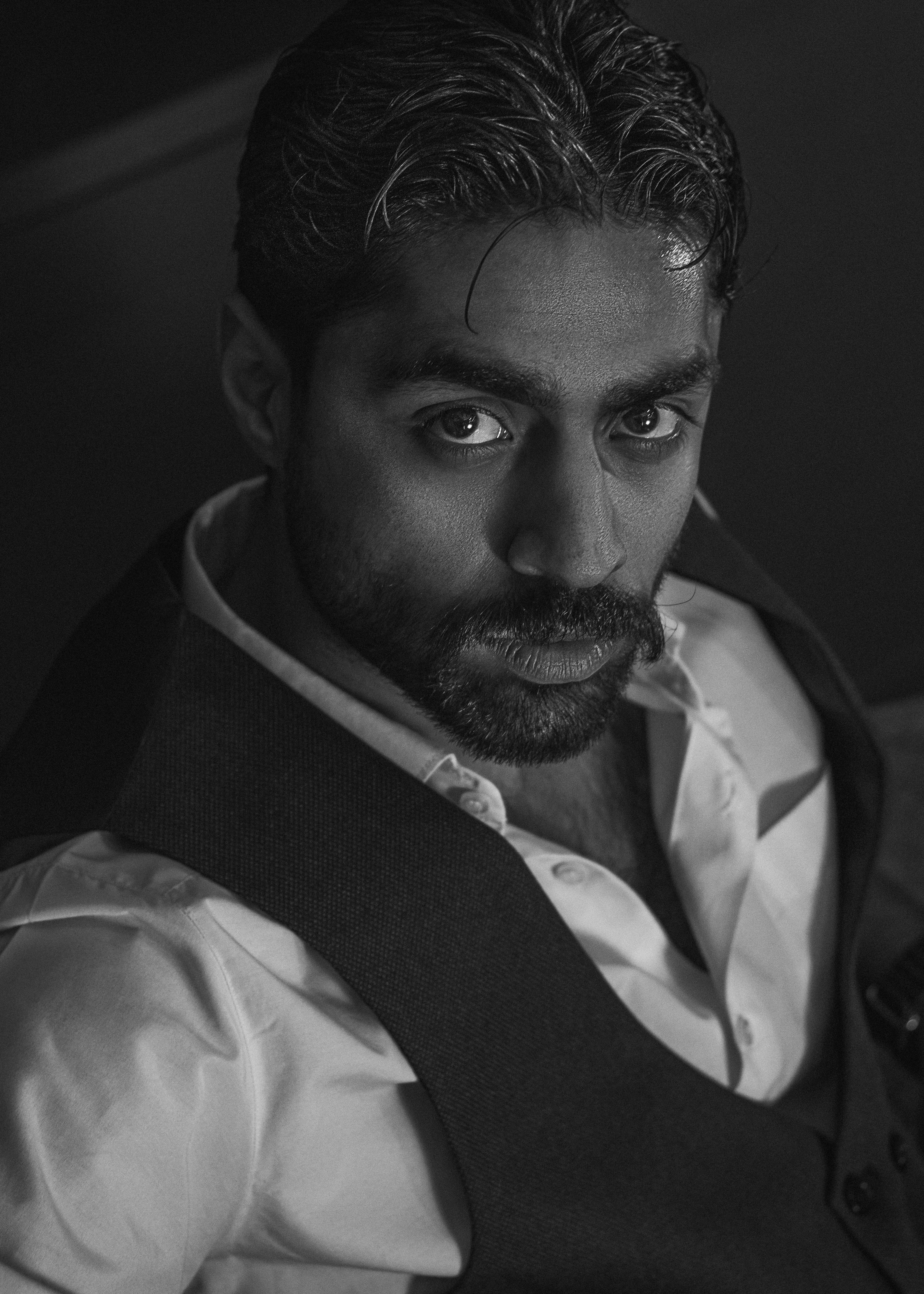 A striking black and white portrait of a man in formal attire exuding a contemplative mood.