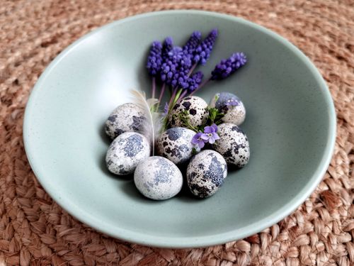 Free Aesthetic arrangement of quail eggs and lavender in a green bowl on a woven mat. Stock Photo