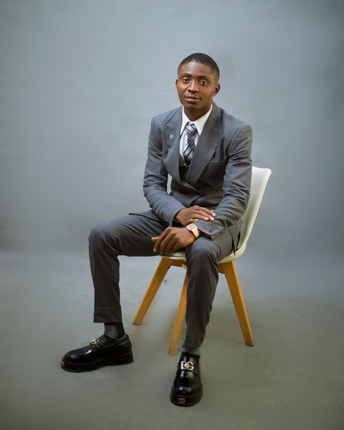 Free Businessman in gray suit sitting on chair, studio portrait. Stock Photo