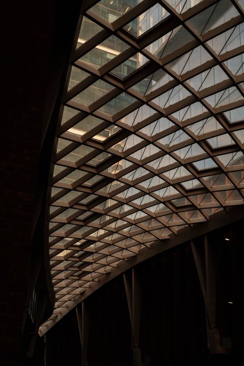 Δωρεάν Περίπλοκη γεωμετρική σχεδίαση γυάλινης οροφής με φυσικό φως που δημιουργεί μια ζεστή ατμόσφαιρα σε εσωτερικούς χώρους. Φωτογραφία από στοκ φωτογραφιών