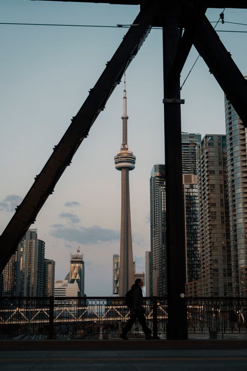 Free Silhouette of a person walking with the CN Tower in Toronto's skyline at dusk. Stock Photo