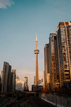 The CN Tower amidst Toronto's modern skyline during sunset, capturing the city's iconic urban architecture.