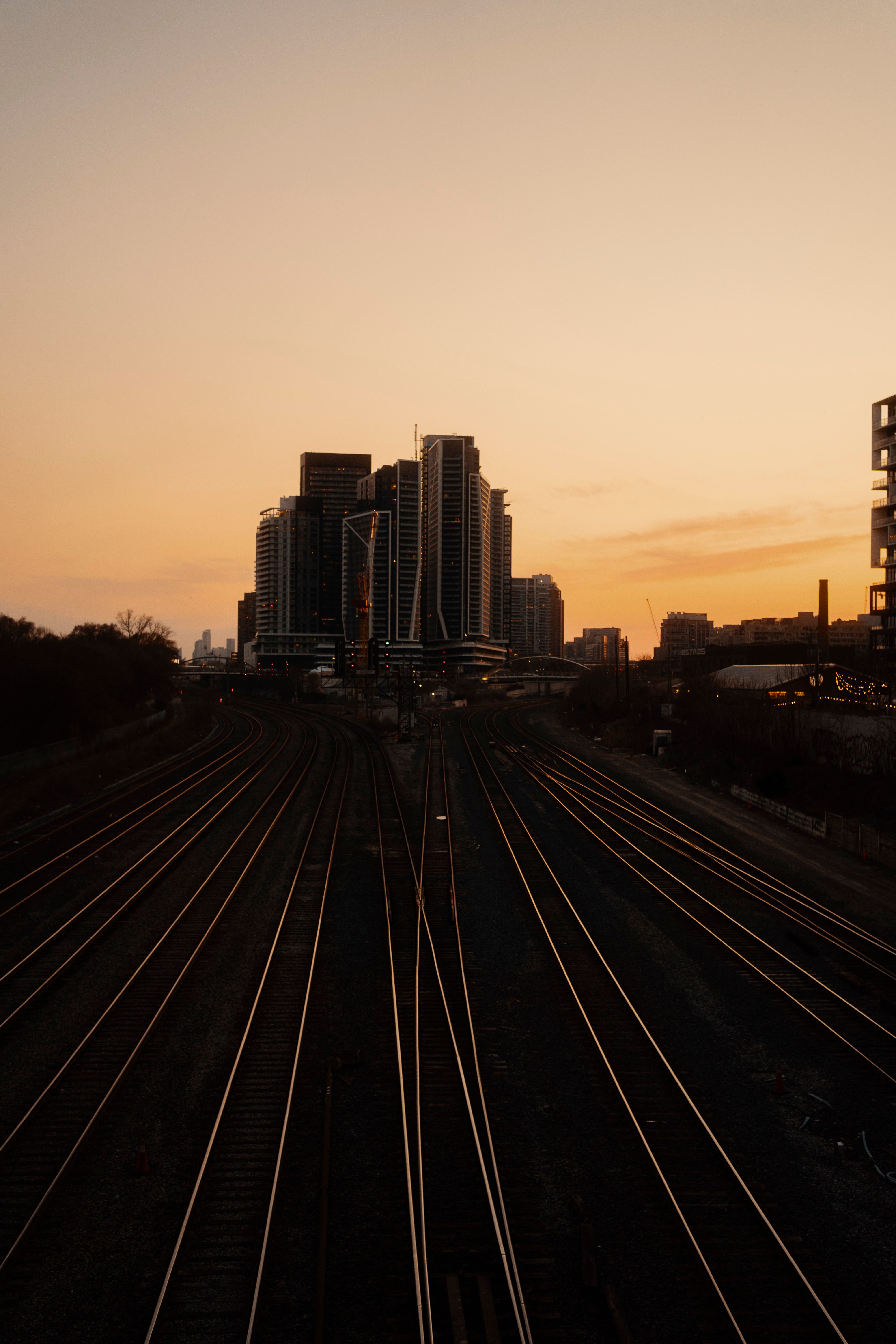 Dramatic Urban Skyline at Twilight Over Rail Tracks · Free Stock Photo
