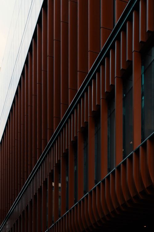 Free Close-up view of a modern building facade featuring vertical lines and glass panels. Stock Photo