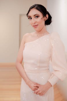 Sophisticated woman in a white designer evening gown indoors. Elegant fashion portrait.