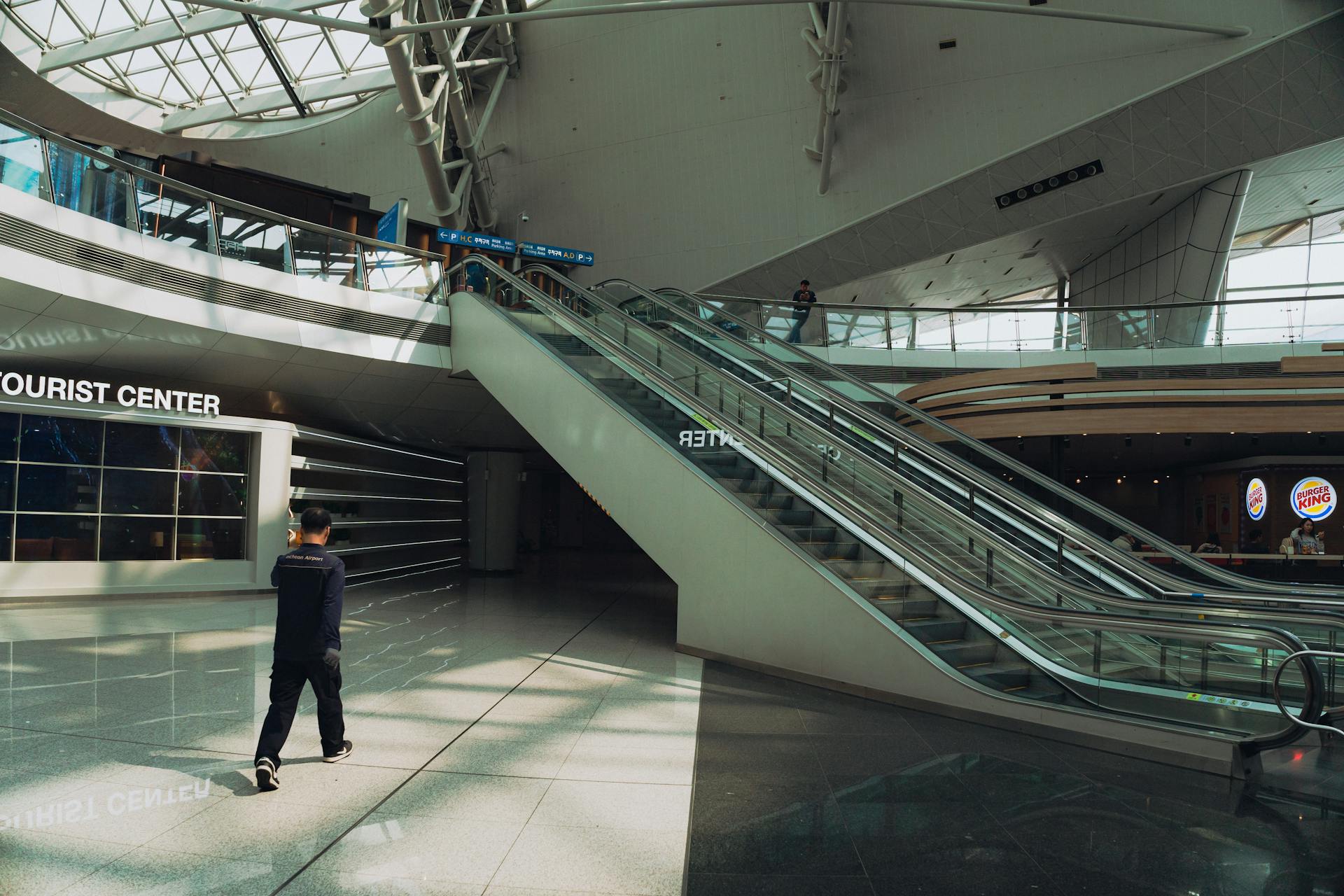 Spacious interior view of Seoul Incheon Airport showcasing escalators and tourist center.