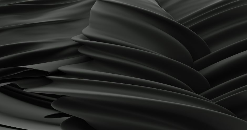 Elegant abstract image of undulating black satin fabric with fluid, smooth folds.