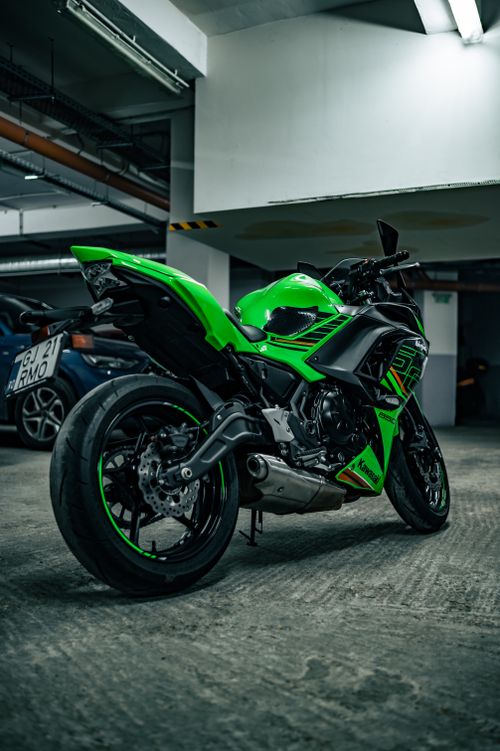 Free Striking green motorcycle parked indoors, showcasing sleek design and urban vibe. Stock Photo