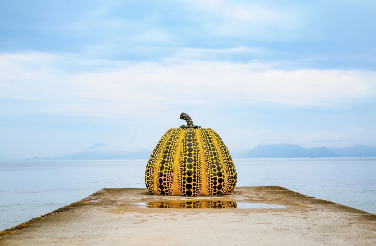 Yellow pumpkin sculpture on Naoshima Island pier — the ferry landing and waterfront art trail