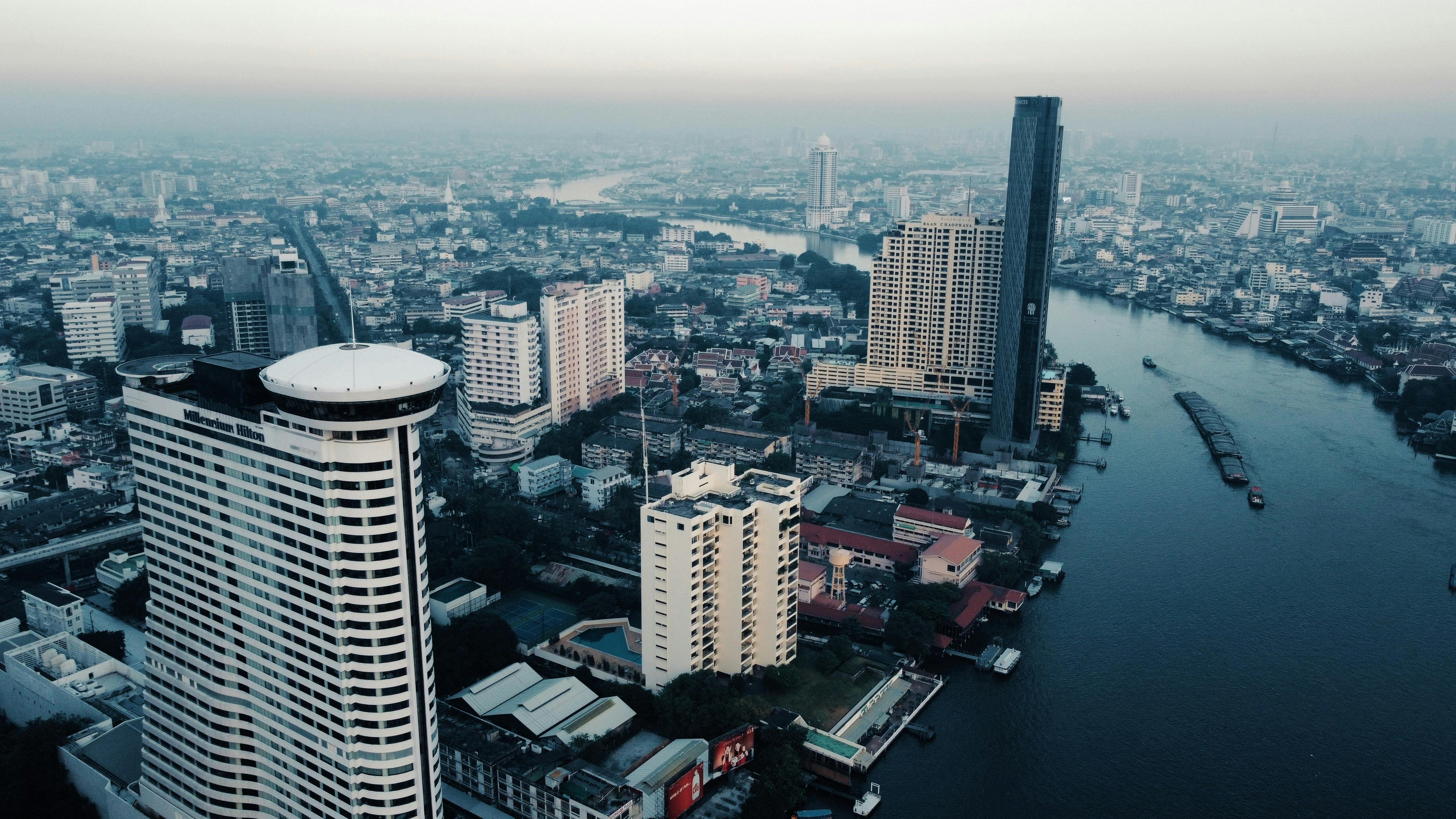 Stunning aerial view of Bangkok cityscape with Chao Phraya River and modern buildings.