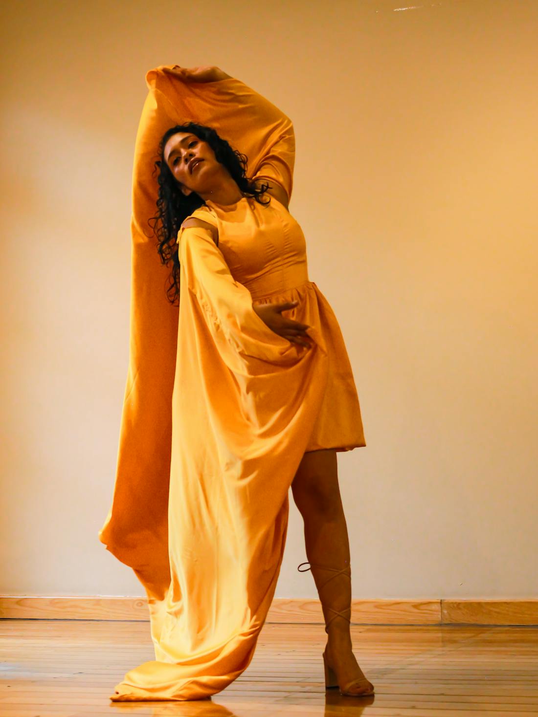 Vibrant yellow maxi with a dramatic cape overlay captured indoors