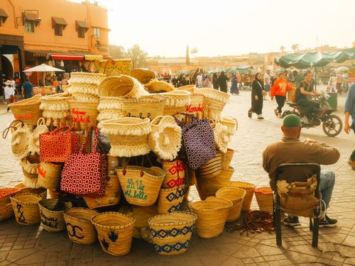 Free Colorful woven baskets on display at a busy street market in Marrakesh, Morocco, showcasing local craftsmanship. Stock Photo