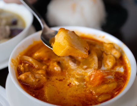 Close-up of a vibrant curry dish with fresh ingredients in a Tokyo restaurant setting.