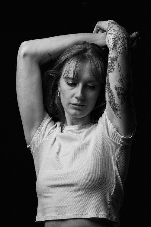 Free Striking black and white portrait of a tattooed woman in a thoughtful pose. Stock Photo