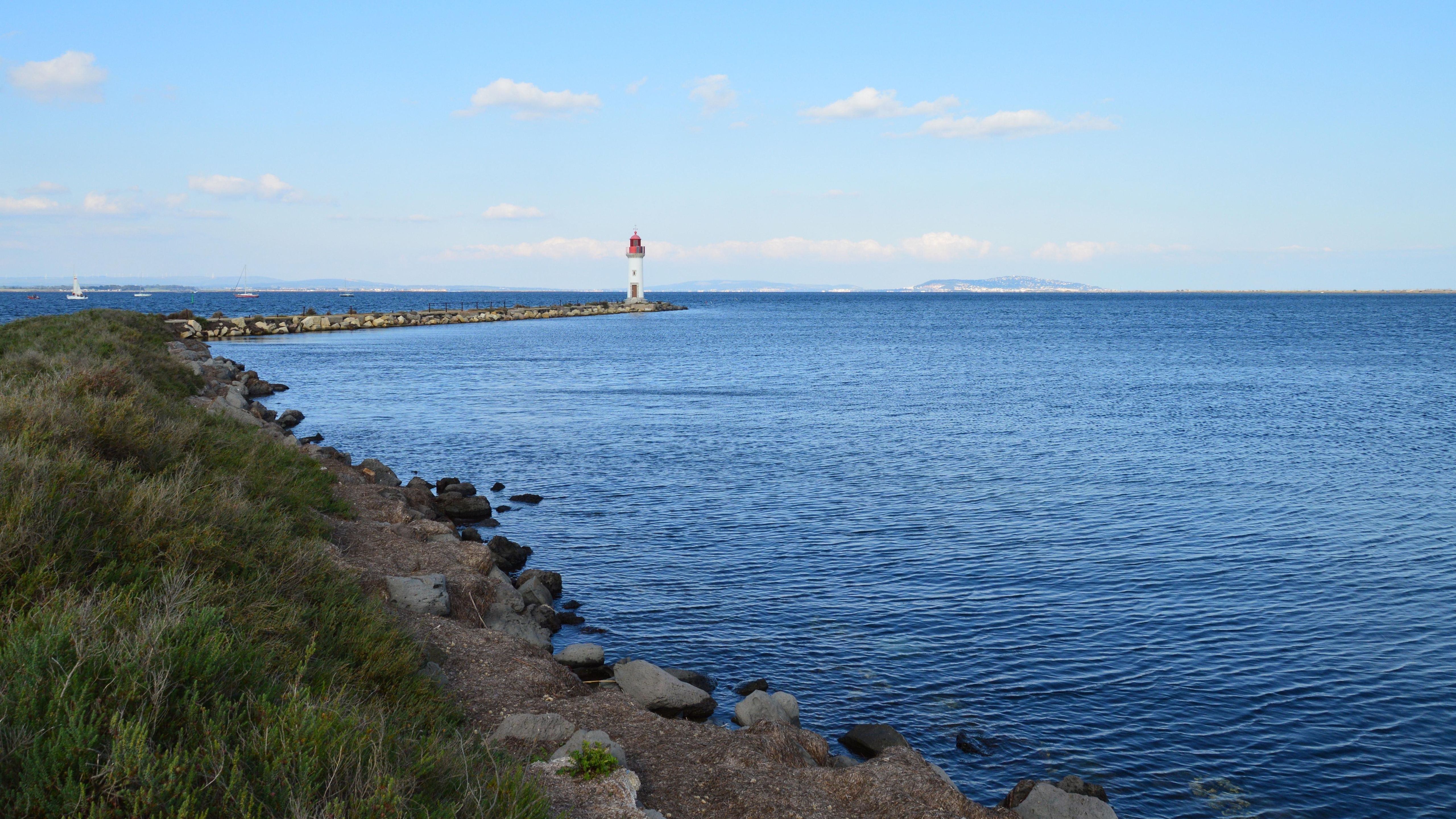 Scenic Coastal View with Lighthouse in Distance · Free Stock Photo