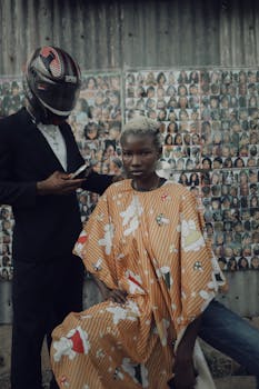 A stylish barber scene with Afrocentric fashion elements against a collage backdrop.