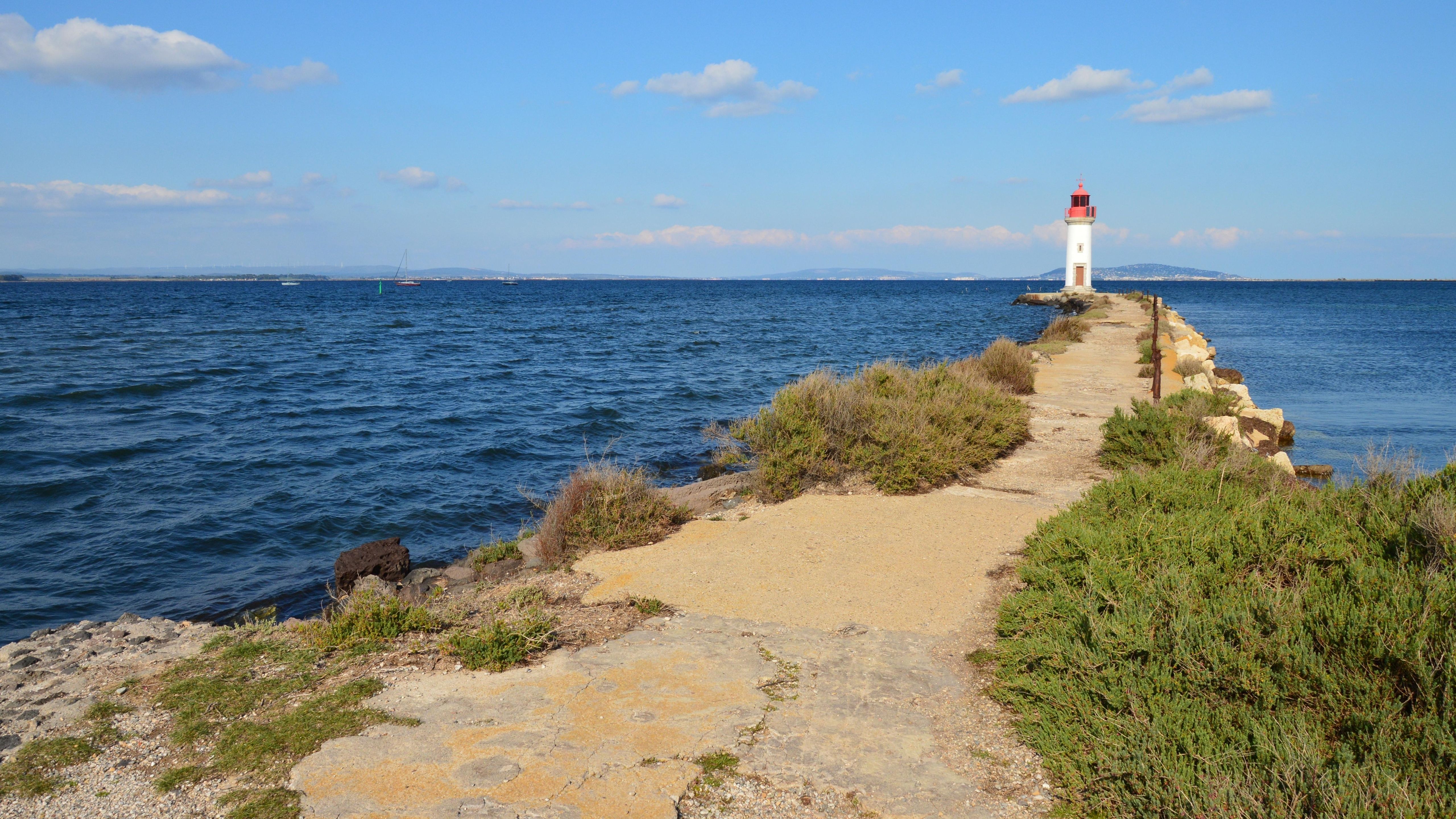Scenic View of Lighthouse on Coastal Pathway · Free Stock Photo