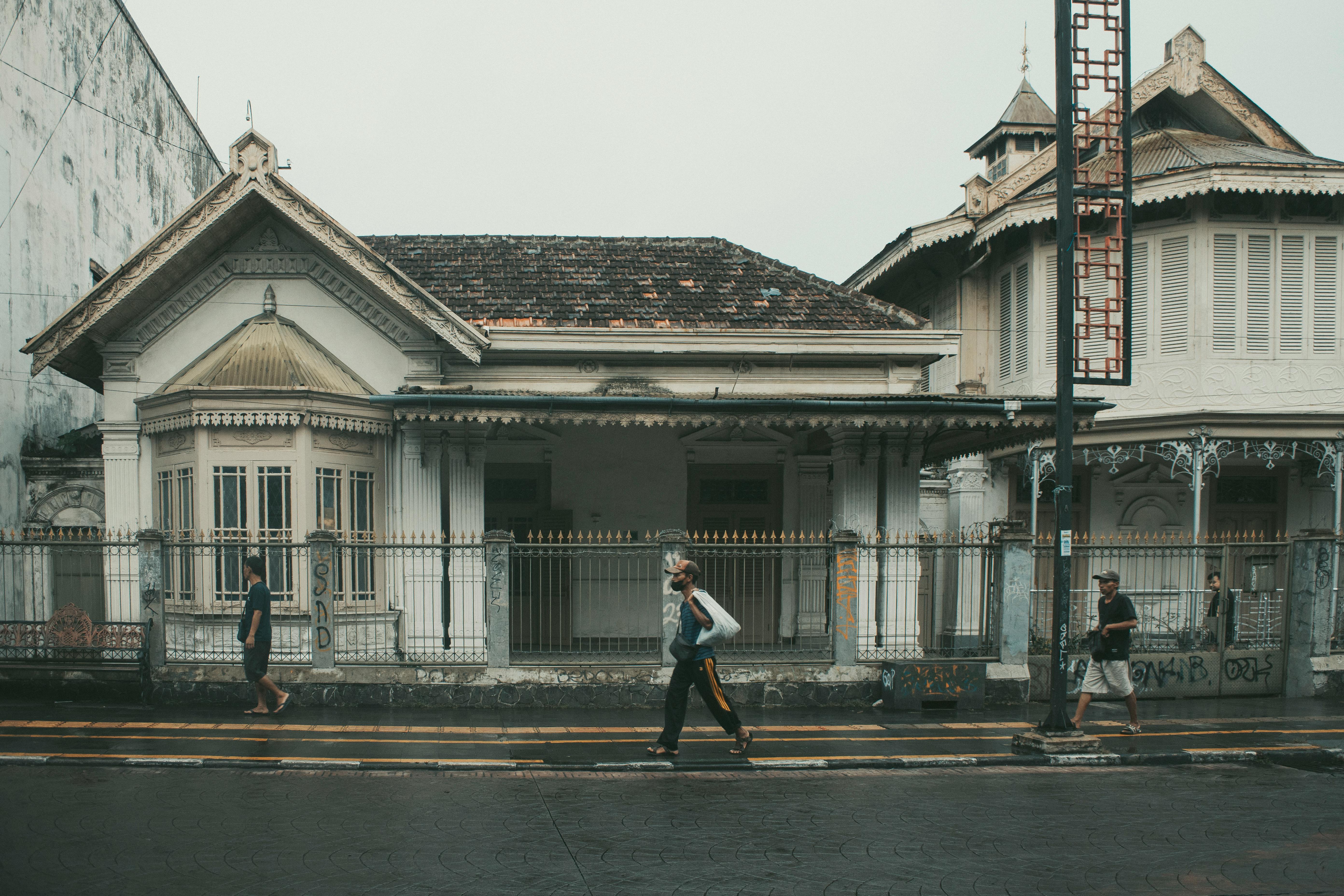 Street view of historic colonial houses in West Java, Indonesia with pedestrians.
