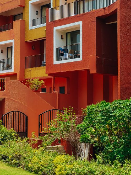 Free Colorful modern apartment building with balconies and lush greenery. Stock Photo