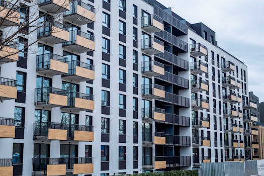 Contemporary apartment building with balconies in urban setting, showcasing modern architecture.