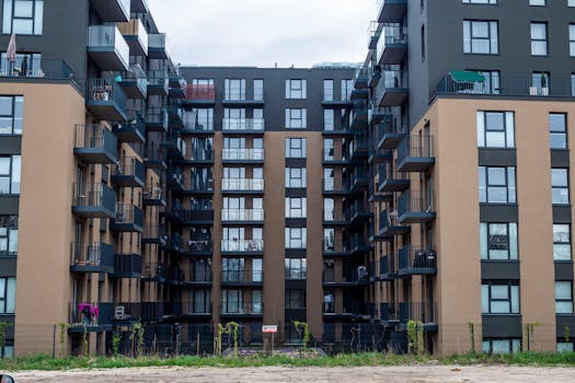 Contemporary apartment building facade with balconies in an urban setting.